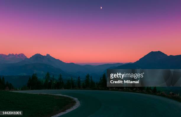landscape with blue silhouettes of mountains during sunset. alps. europe. - purple sunset stock pictures, royalty-free photos & images