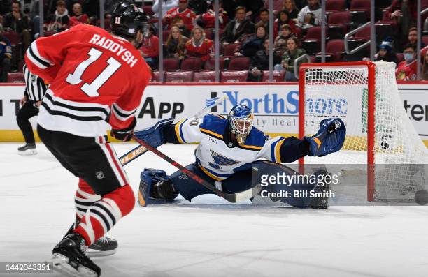 Jordan Binnington of the St. Louis Blues makes a save on Taylor Raddysh the Chicago Blackhawks during the first period at United Center on November...