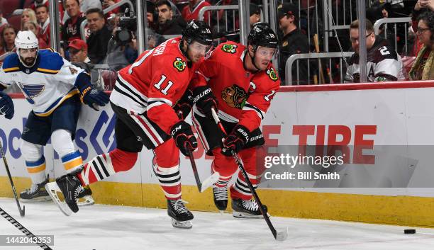 Jonathan Toews and Taylor Raddysh of the Chicago Blackhawks go for the puck against the St. Louis Blues during the first period at United Center on...