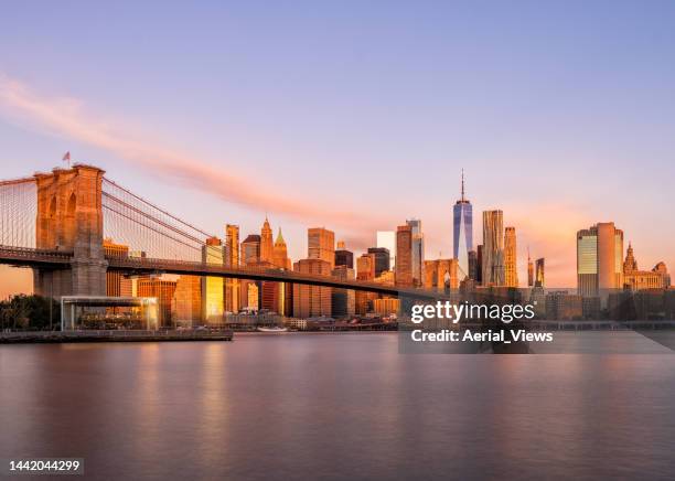 iconic view of nyc skyline and brooklyn bridge at sunrise - nyc skyline stock pictures, royalty-free photos & images