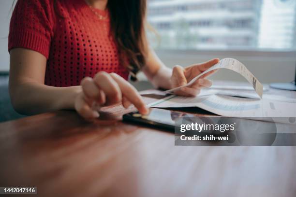 femme qui pense aux prix élevés tout en regardant les services publics, le gaz, l’électricité, les charges locatives, la planification de son budget personnel tout en étant assise dans la chambre à coucher - chèque photos et images de collection