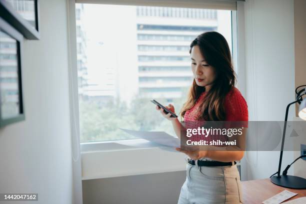 woman thinking about high prices while looking at utilities, gas, electricity, rental charges, planning personal budget while sitting in bedroom - legislation change stock pictures, royalty-free photos & images