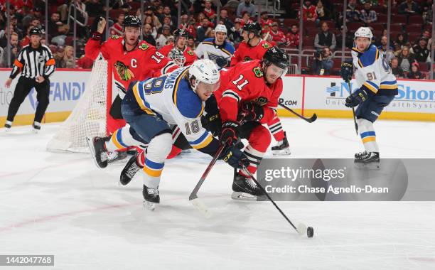Robert Thomas of the St. Louis Blues and Taylor Raddysh of the Chicago Blackhawks go for the puck during the first period at United Center on...