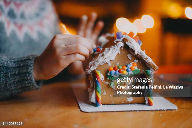 child making gingerbread house - gingerbread house stock pictures, royalty-free photos & images