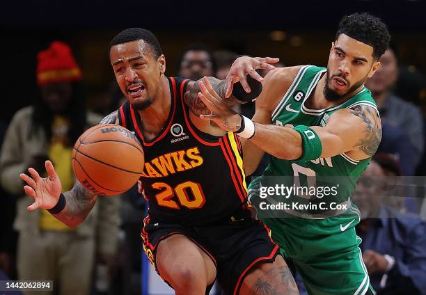 Jayson Tatum of the Boston Celtics knocks the ball away from John Collins of the Atlanta Hawks during the first half at State Farm Arena on November...