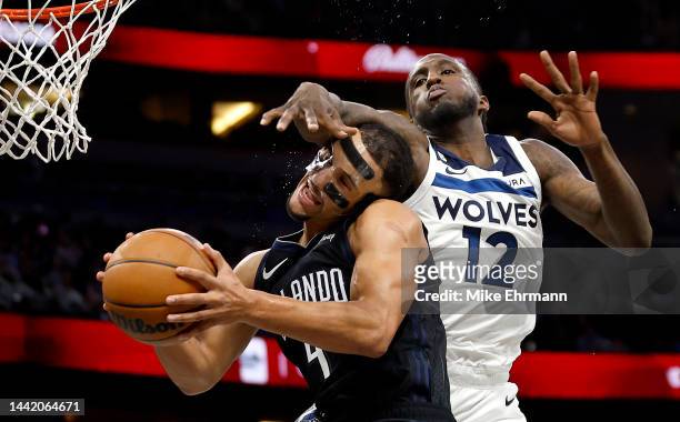 Jalen Suggs of the Orlando Magic is fouled by Taurean Prince of the Minnesota Timberwolves during a game at Amway Center on November 16, 2022 in...