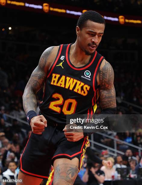 John Collins of the Atlanta Hawks reacts after dunking over Luke Kornet of the Boston Celtics during the second half at State Farm Arena on November...