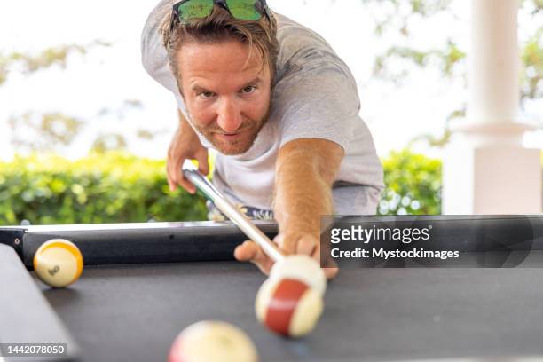 young happy man enjoying in a billiard game - billiard ball game stockfoto's en -beelden
