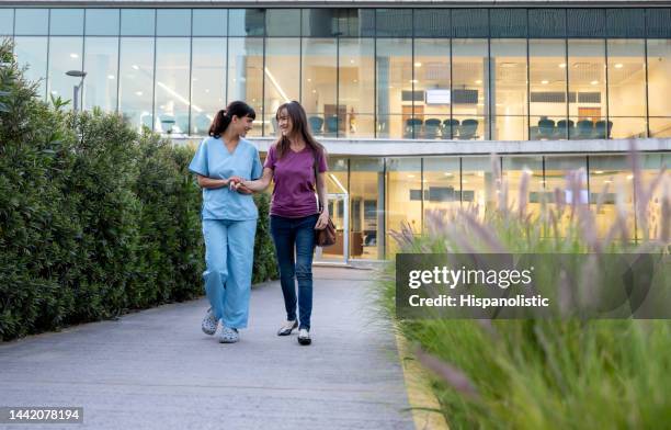 nurse assisting a patient in remission leaving the hospital - healthcare facilities stock pictures, royalty-free photos & images