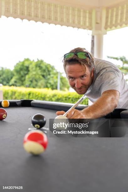 young happy man enjoying in a billiard game - billiard ball game stockfoto's en -beelden