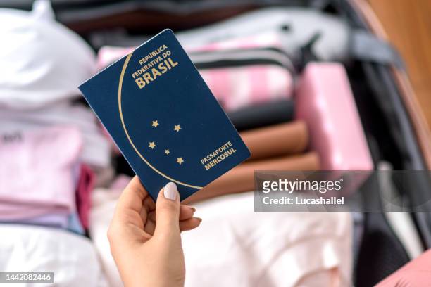 ragazza che tiene un passaporto brasiliano - oggetti personali foto e immagini stock