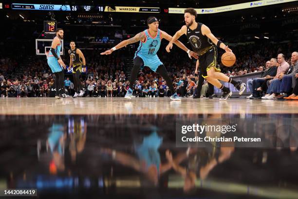 Klay Thompson of the Golden State Warriors handles the ball against Damion Lee of the Phoenix Suns during the first half of the NBA game at Footprint...