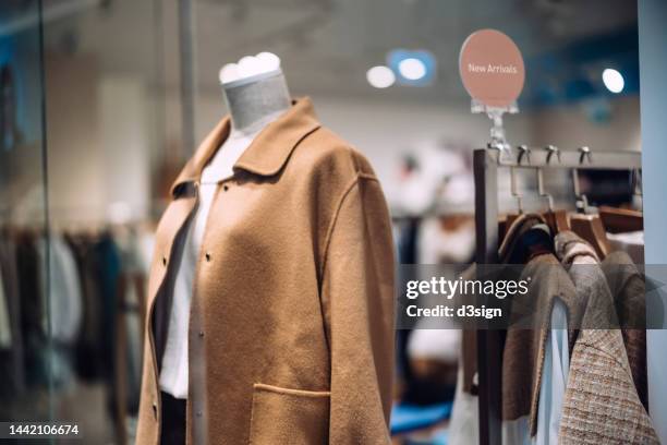 women's clothing displayed in the boutique window. retail and consumerism - multi colored dress photos et images de collection