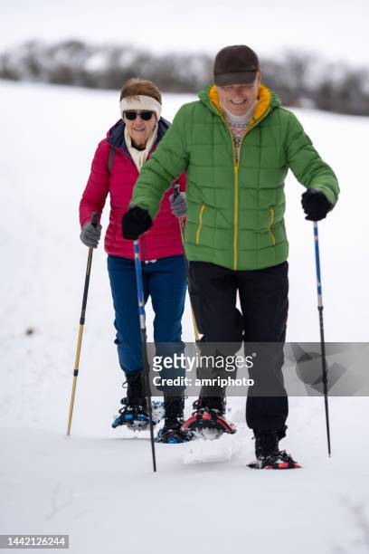 cheerful senior couple snowshoeing - winter sport walk old stock pictures, royalty-free photos & images