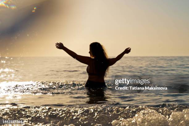 beautiful woman silhouette in the sea, sunset light. lens flare. - relaxed sunshine happy lens flare bildbanksfoton och bilder