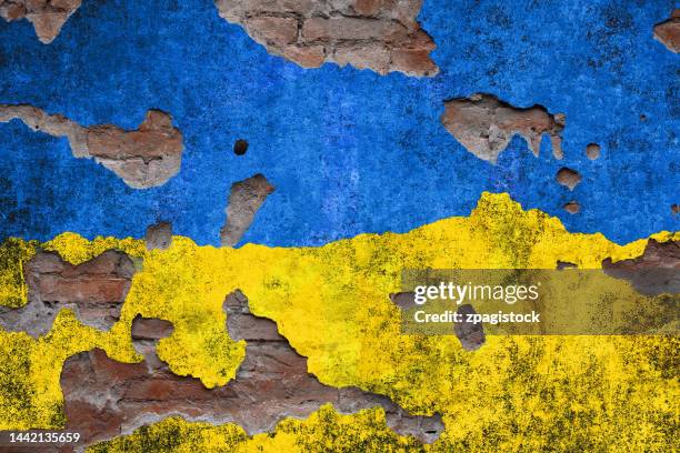 ukraine colors on damaged wall - russische-invasion-in-die-ukraine stock-fotos und bilder