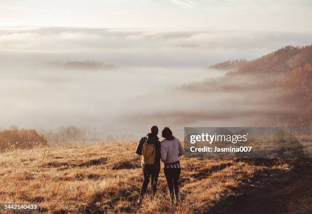 giovani coppie che si godono sulla collina in campagna all'alba - ora del giorno foto e immagini stock