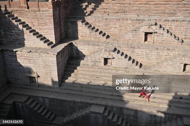 tourist mother and daughter sitting at step well in jodhpur - jodhpur stock pictures, royalty-free photos & images