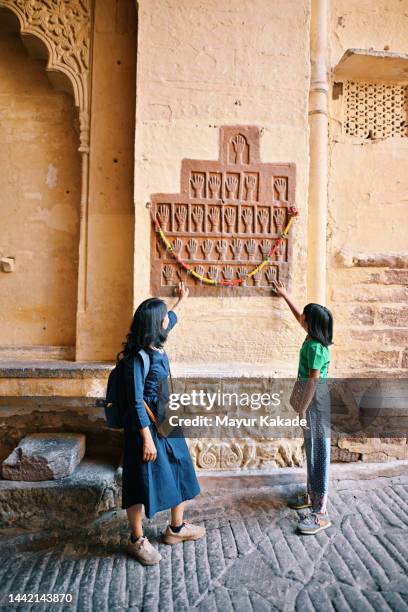 tourist mother and daughter looking at the handprints of sati on the wall, meharangarh fort jodhpur - meherangarh fort stock pictures, royalty-free photos & images