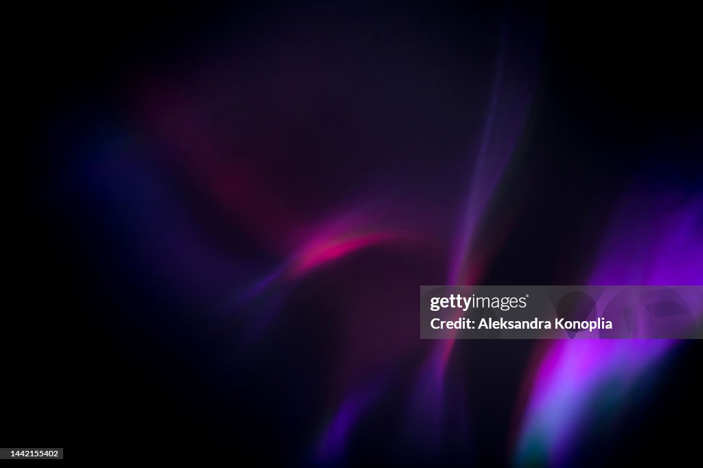 Colorful neon rainbow aurora borealis or laser light leaks texture on black background