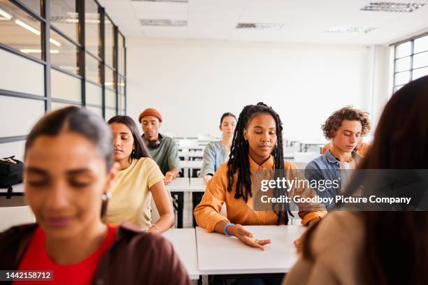 students sitting in a classroom and doing a visualization exercise - teenager meditating stock pictures, royalty-free photos & images