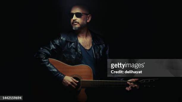 guitarist on stage. man playing guitar in a dark environment - folk music stock pictures, royalty-free photos & images