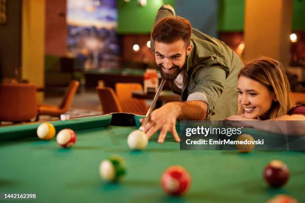 pares felizes novos que apreciam jogar o bilhar junto no salão de associação - snooker - fotografias e filmes do acervo