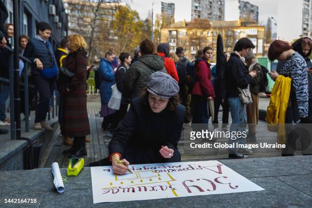 Girl draws a poster on the stairs of the Dovzhenko Center during action "Manifestation of Will" on November 12, 2022 in Kyiv, Ukraine. Employees of...