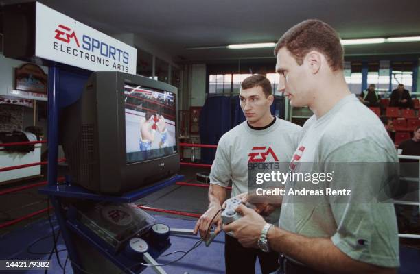 Ukrainian boxer Wladimir Klitschko and his brother, Ukrainian boxer Vitali Klitschko, both wearing t-shirts bearing the logo of video game company...
