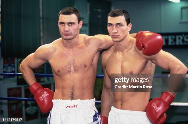Ukrainian boxer Vitali Klitschko with his arm around his brother, Ukrainian boxer Wladimir Klitschko pose in shorts and boxing gloves in Hamburg,...