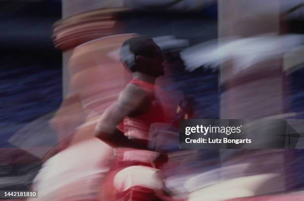 Black athlete, obscured by motion blur, competes in an track event at the 1988 Summer Olympics, possibly at the Seoul Olympic Stadium in Seoul, South...