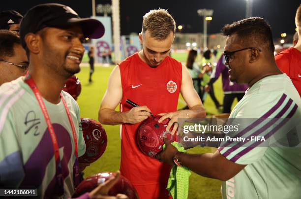 Liam Millar of Canada signs autographs for FIFA volunteers during the FIFA Community Engagement Event with Canada on November 14, 2022 in Doha, Qatar.