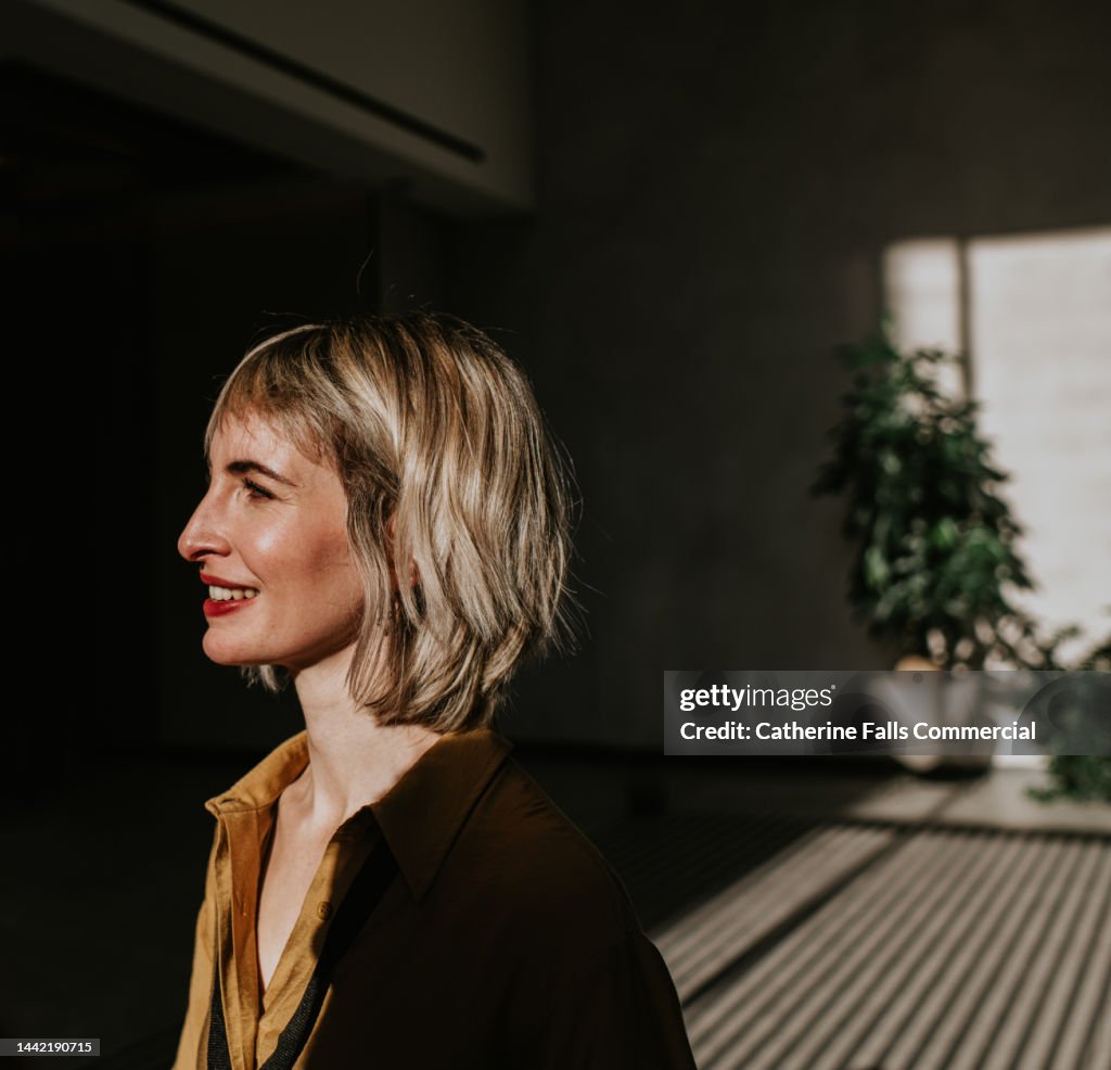 Portrait of a beautiful young woman with a nose ring, enveloped in shadows, illuminated by sunlight