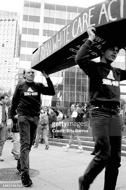 Demonstrators carry a mock coffin during an event organized by ACT UP , in Foley Square , New York, New York, October 16, 1990. Text on the coffin...