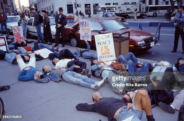 Demonstrators, many with signs, participate in a die-in organized by ACT UP , in Foley Square , New York, New York, October 16, 1990. Among the...
