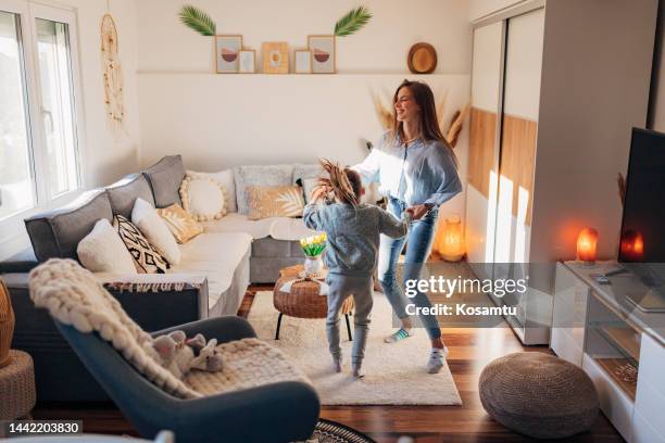 glückliche offene frau, die am wochenende mit fröhlicher süßer vorschultochter tanzt - musikalische begleitung stock-fotos und bilder