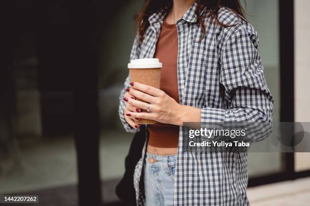 female hand with paper cup of coffee take away. - coffee take away cup simple stock pictures, royalty-free photos & images