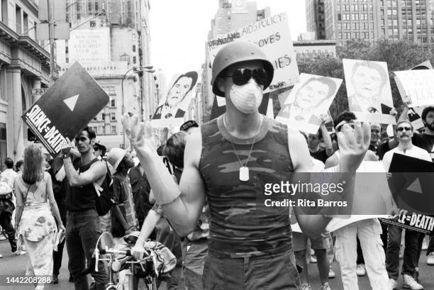 Portrait of a marcher, wearing a helmet, sunglasses, a mask, and rubber gloves during a parade on Fifth Avenue, New York, New York, 1987. Fellow...