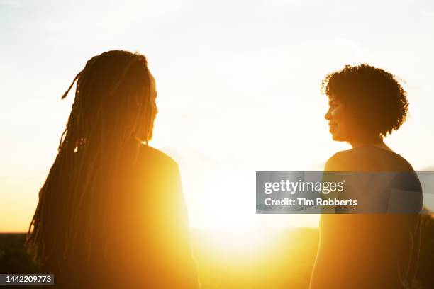man and woman hanging out at sunset - golden hour woman stock pictures, royalty-free photos & images