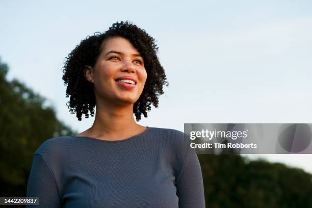 woman smiling, looking up, dusk - esperanza fotografías e imágenes de stock