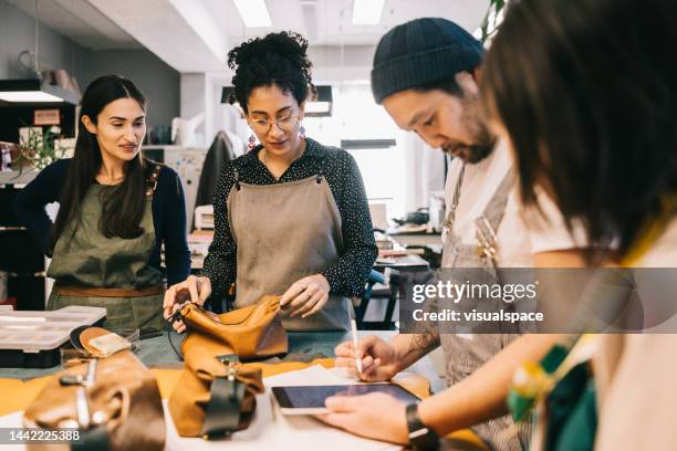 les concepteurs de produits analysent un nouveau prototype de produit - travail du cuir photos et images de collection