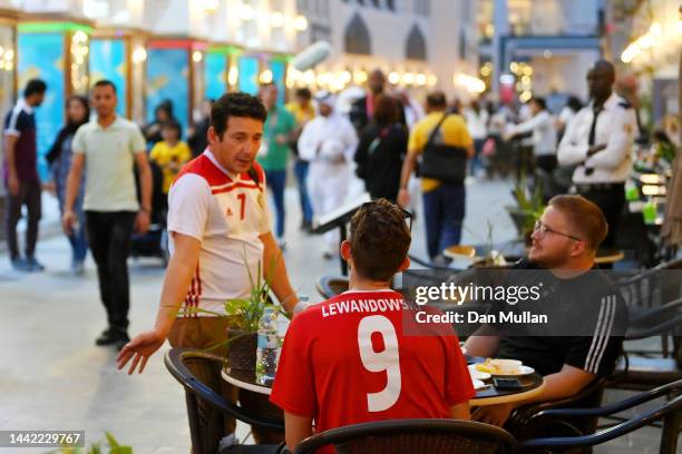 Poland fans, one wearing a Lewandowski shirt sit at restaurant ahead of the FIFA World Cup Qatar 2022 at Souq Waqif on November 17, 2022 in Doha,...