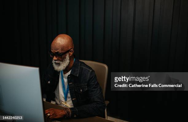 a man works behind a desktop computer. - bell telephone company stock pictures, royalty-free photos & images