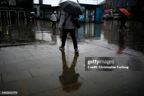 Dismal weather heralds the arrival of the UK Chancellor's Autumn Statement as people shop in the centre of Bolton on November 17, 2022 in Bolton,...