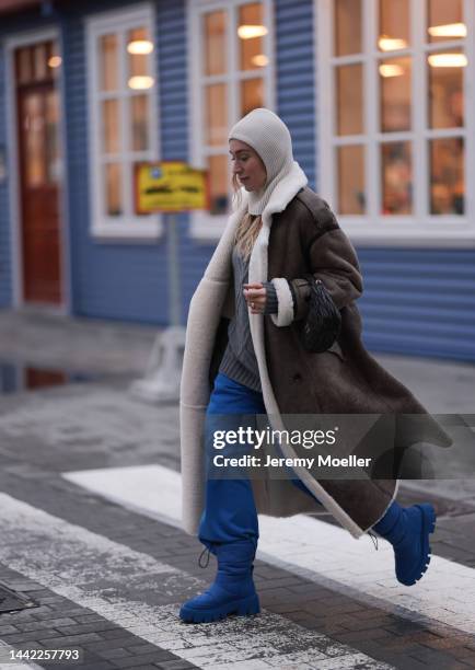 Sonia Lyson is seen wearing Copenhagen Studios CPH149 recycled nylon royal blue boots, H&M blue wide leg jogging pants, Gobi Cashmere grey sweater,...