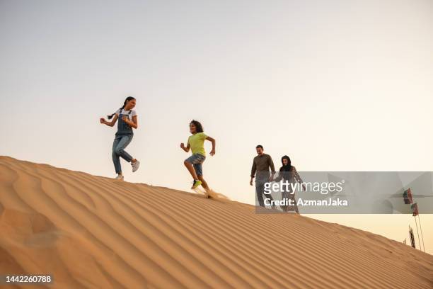 tourists on vacation in dubai desert - young muslim man stockfoto's en -beelden