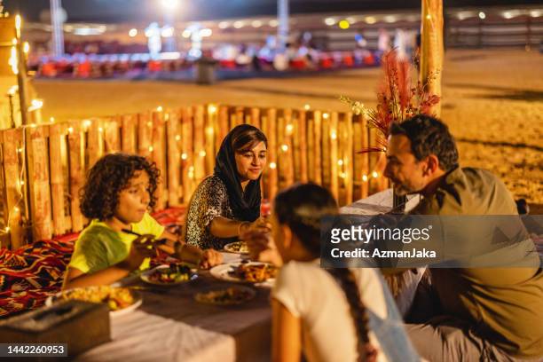 family spending time together at dinner  in dubai - night safari stock pictures, royalty-free photos & images