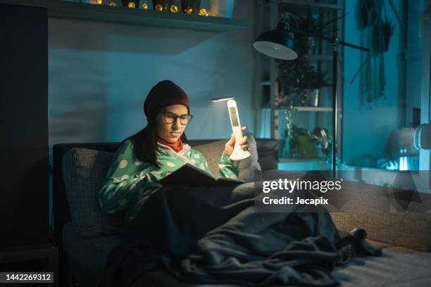 woman reading in dark room - blackout stock pictures, royalty-free photos & images