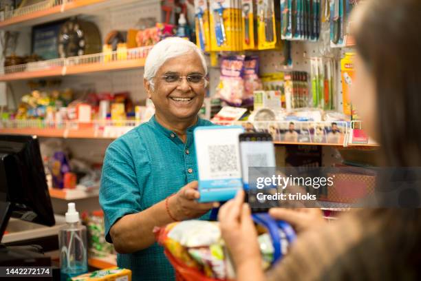 customer scanning qr code with smartphone at store - indian shopkeeper stock pictures, royalty-free photos & images