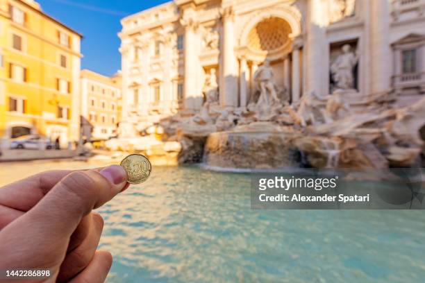 tourist throwing a coin into trevi fountain, rome, italy - blessing fotografías e imágenes de stock